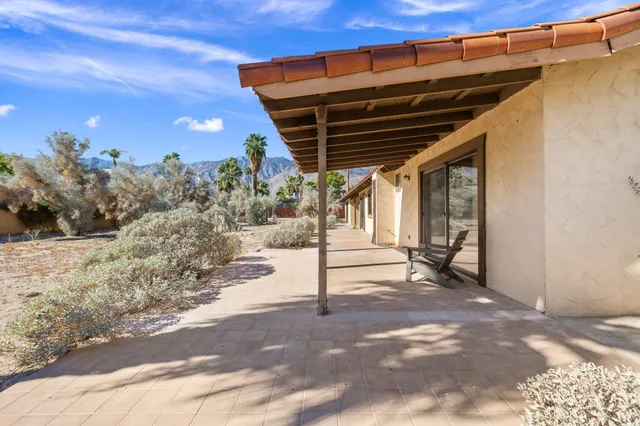 a view of a room with table and chairs next to a yard