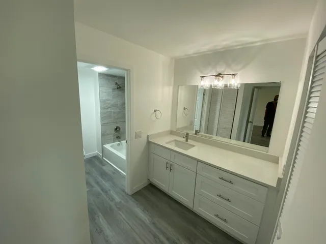 a bathroom with a double vanity sink toilet and mirror