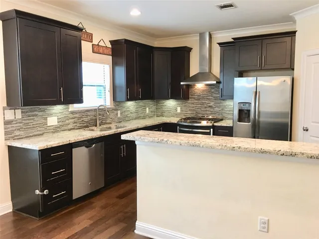 a kitchen with stainless steel appliances granite countertop a sink stove and refrigerator