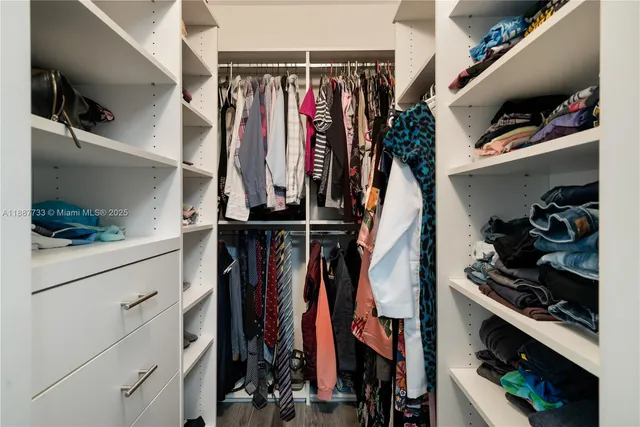 a view of walk in closet with clothes and shoes