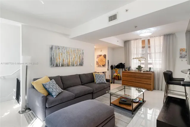 a living room with furniture a couch and a window