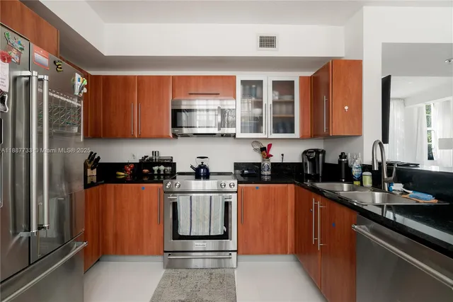 a kitchen with stainless steel appliances granite countertop a refrigerator sink and cabinets