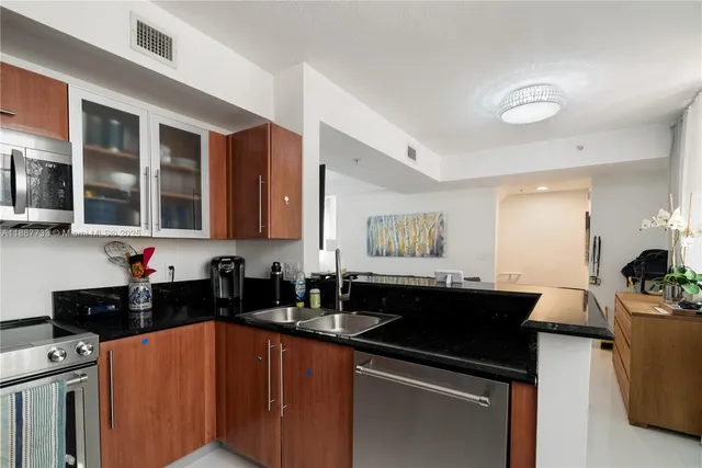 a kitchen with a sink and a stove top oven with wooden floor