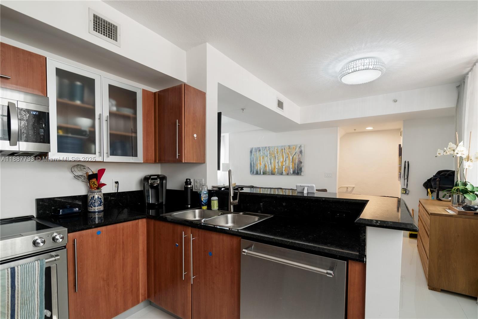 3232 Southwest 22nd Terrace, Unit TH 115 Miami, FL 33145 - Photo 6 of 17 a kitchen with a sink and a stove top oven with wooden floor