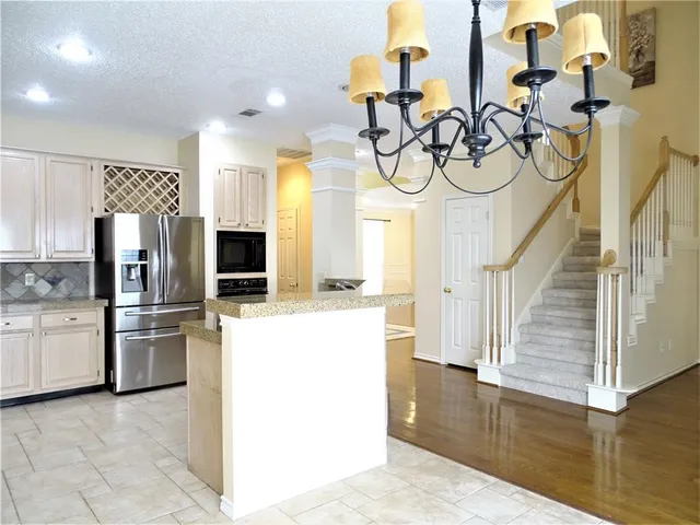 a kitchen with stainless steel appliances granite countertop a refrigerator and a sink