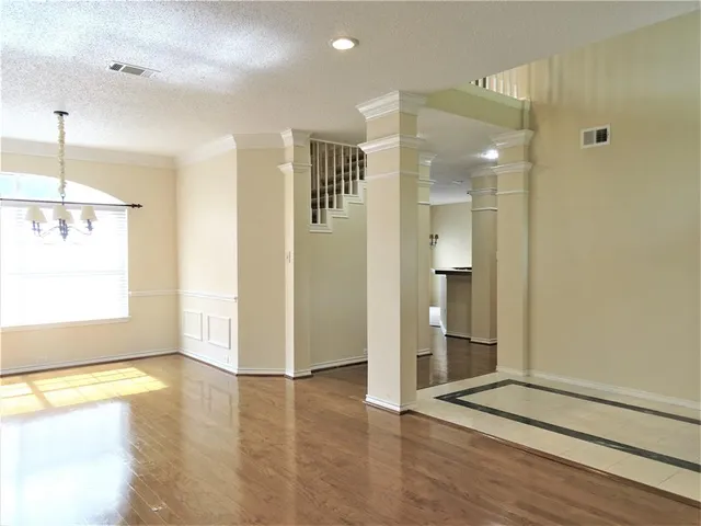 a view of a hallway with wooden floor and a bathroom