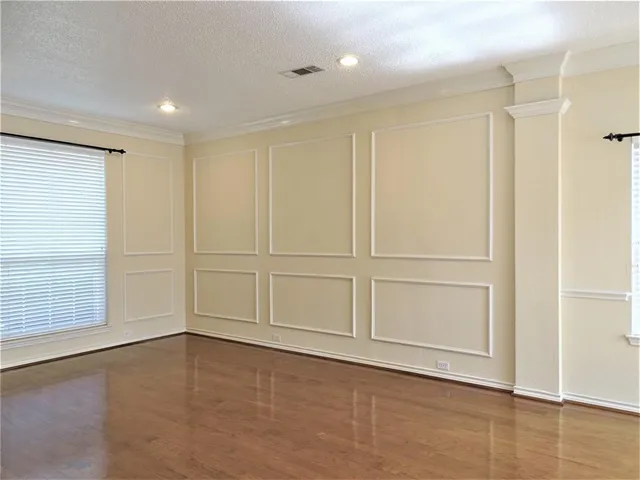 an empty room with wooden floor and cabinet