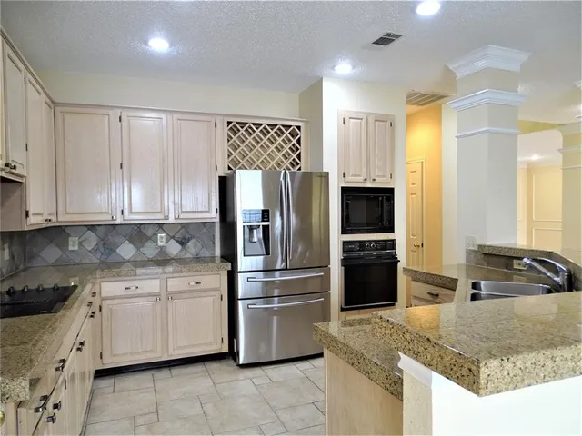 a kitchen with granite countertop a refrigerator and a sink