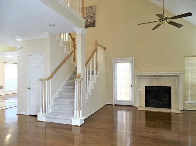 a view of a livingroom with wooden floor fireplace and a window