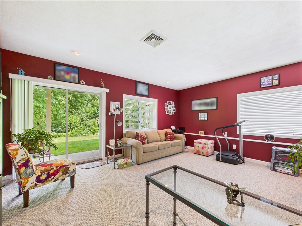 200 Cannon Street, Unit 130 Cranston, RI 02920 - Photo 15 of 26 3rd bedroom offers privacy for visiting family and friends and ensuite full bath. Couch opens to a bed. This room has also served as an office/family room. Note the absolute PRIVACY in the backyard with the wooded rear.