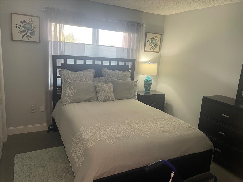 9818 Marina Boulevard, Unit 1220 Boca Raton, FL 33428 - Photo 10 of 18 a bedroom with a bed and window