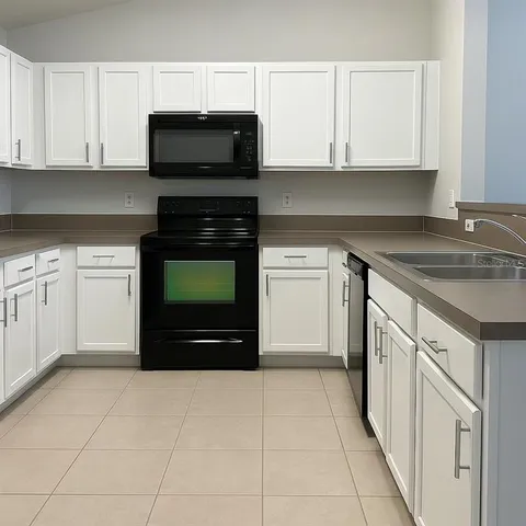 a kitchen with granite countertop a stove top oven and cabinets