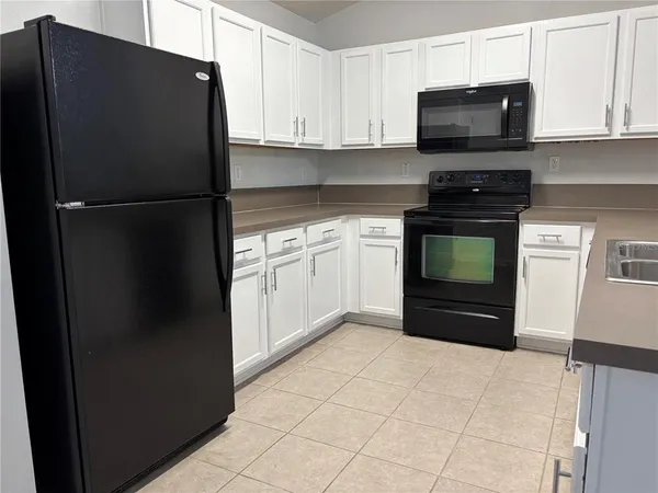 a kitchen with a refrigerator stove and microwave