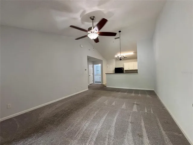 a view of a room with a ceiling fan and window
