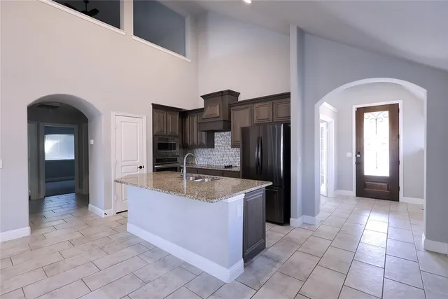 a kitchen with stainless steel appliances granite countertop a refrigerator and a sink