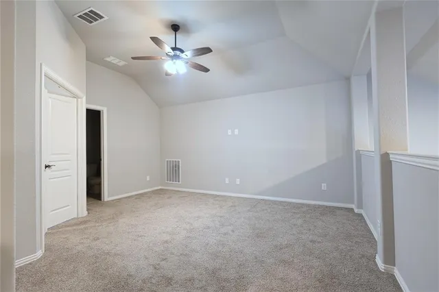 a view of an empty room with a chandelier fan