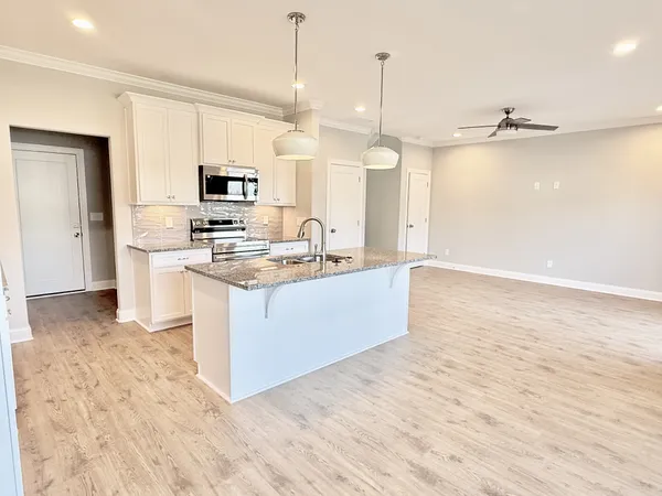a large kitchen with kitchen island a sink stainless steel appliances and cabinets