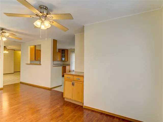 a view of a kitchen with wooden floor and a ceiling fan