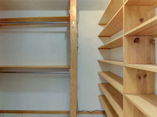 a view of a hallway with wooden floor and a living room