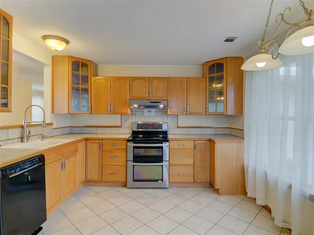 a kitchen with stainless steel appliances granite countertop a stove a sink and a refrigerator