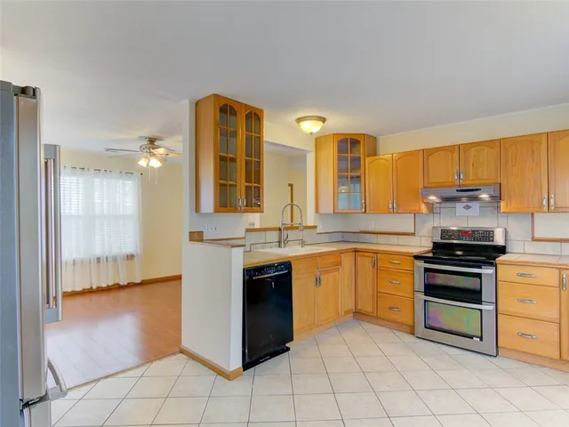 a kitchen with stainless steel appliances granite countertop a stove a sink and a refrigerator