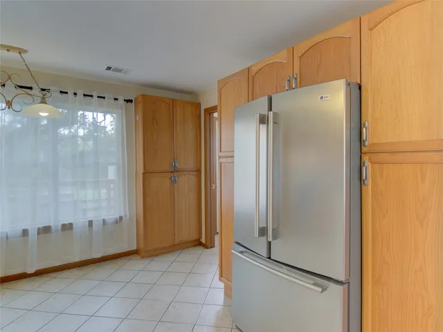 a metallic refrigerator freezer sitting in a kitchen
