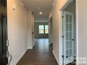 a view of a hallway with wooden floor and windows