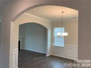an empty room with wooden floor mirror and windows