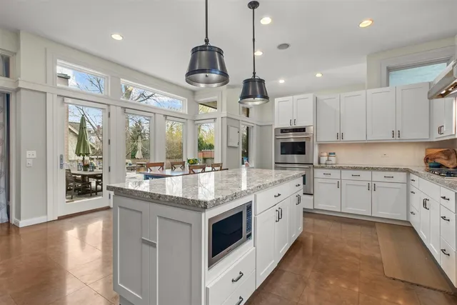 a kitchen with granite countertop white cabinets and white appliances