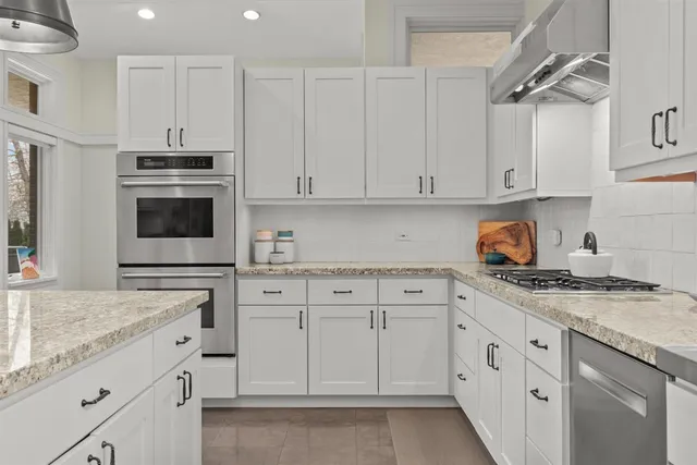 a kitchen with granite countertop a sink a center island a counter space and a view of living room