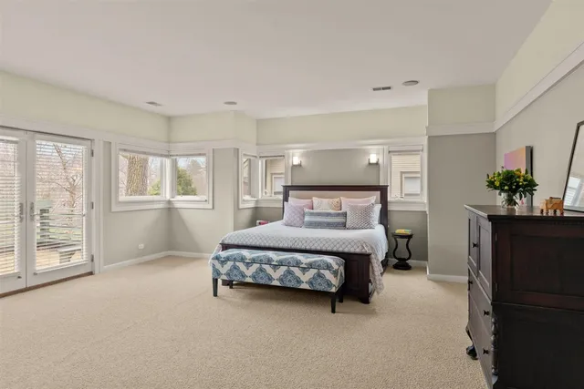 a bedroom with a bed table chair and window