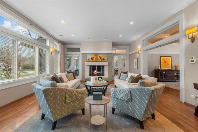 a living room with fireplace furniture and a large window