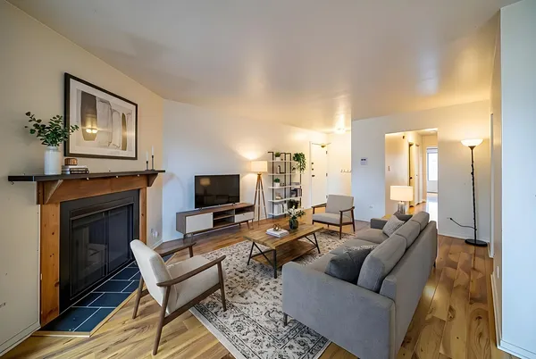 a living room with furniture a fireplace and a flat screen tv