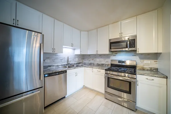 a kitchen with cabinets stainless steel appliances and a sink