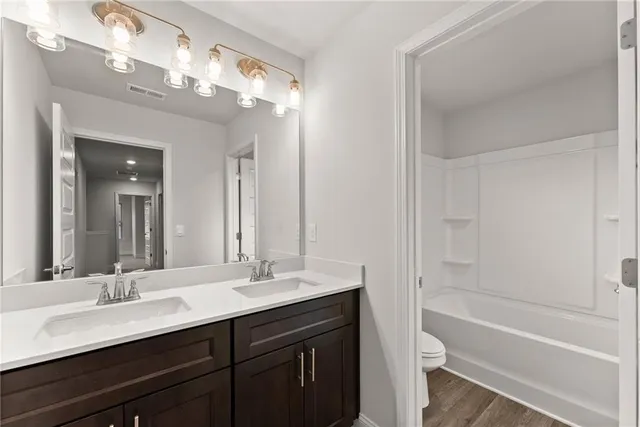 a bathroom with a tub double sink and mirror