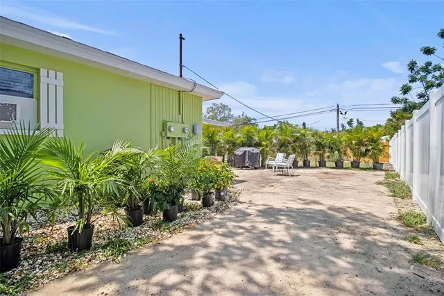 a front view of a house with a yard and potted plants