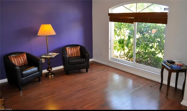 a living room with furniture and a chair with wooden floor