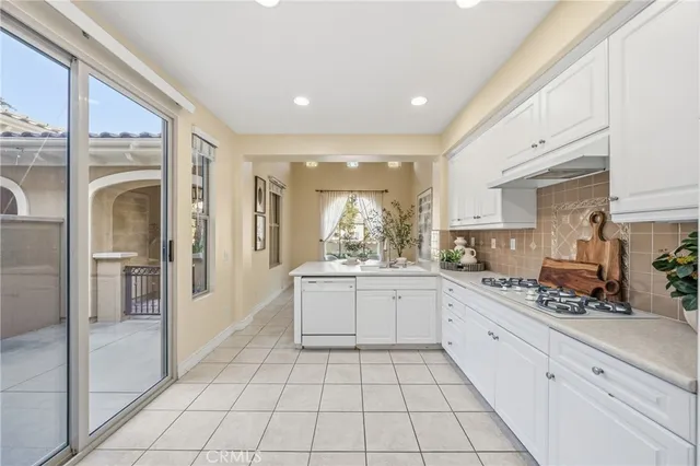 a large white kitchen with cabinets