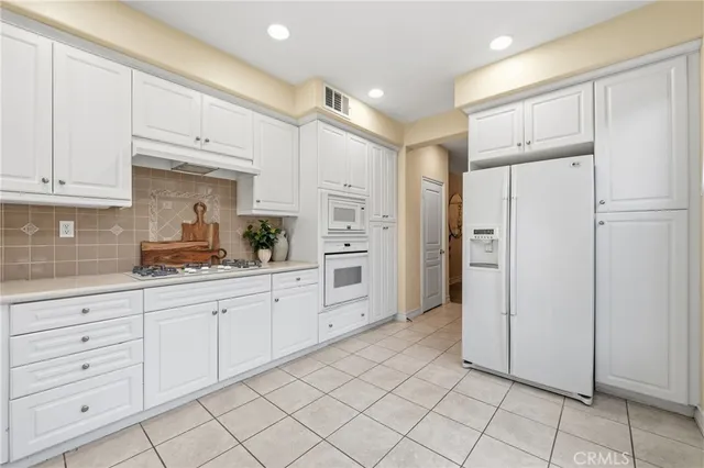 a large white kitchen with cabinets