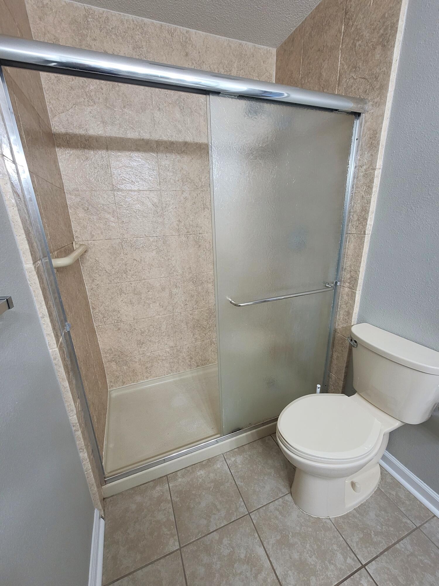 5496 Monterrey Road Crestview, FL 32539 - Photo 11 of 15 a white toilet sitting next to a shower