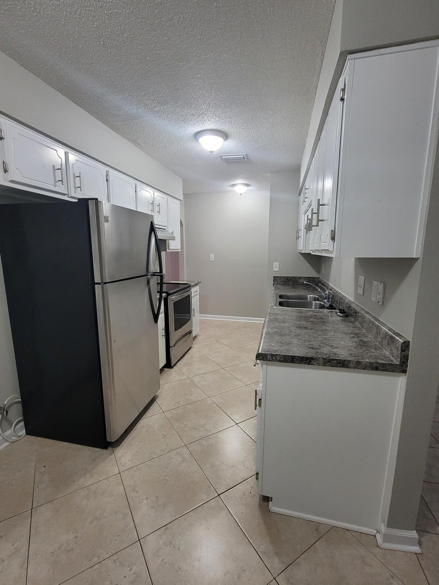 5496 Monterrey Road Crestview, FL 32539 - Photo 4 of 15 a kitchen with stainless steel appliances granite countertop a refrigerator a sink and a stove