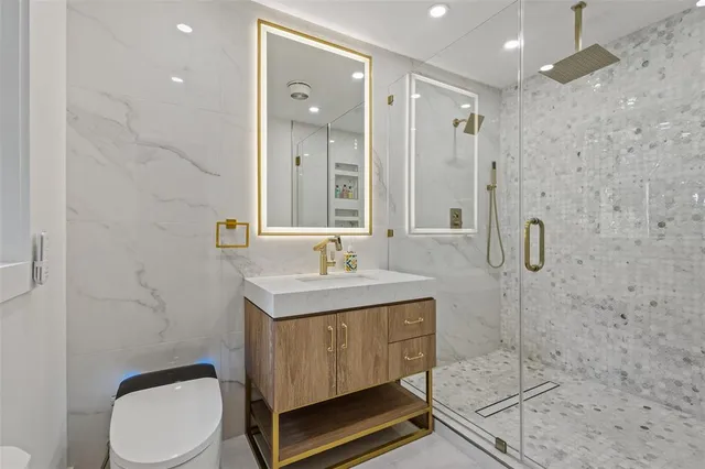 a bathroom with a granite countertop sink toilet a mirror and shower