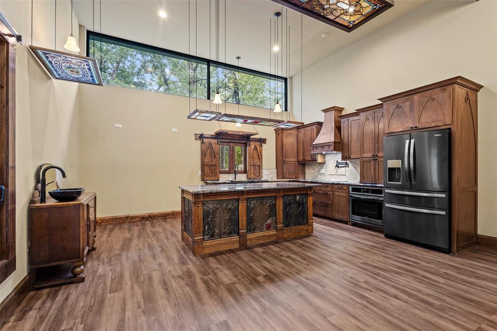 411 Hidden Meadows Lane Denison, TX 75021 - Photo 27 of 40 a kitchen with stainless steel appliances granite countertop a refrigerator a stove and a wooden floors