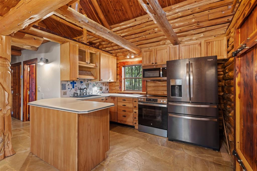 411 Hidden Meadows Lane Denison, TX 75021 - Photo 36 of 40 a kitchen with stainless steel appliances granite countertop a refrigerator a stove and a sink with wooden floors