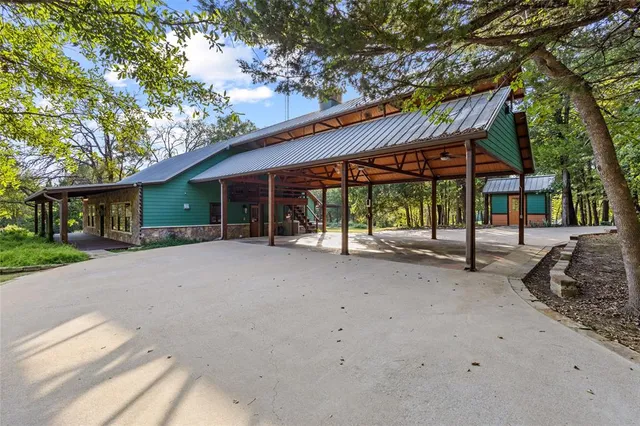 a view of a house with a yard and large tree