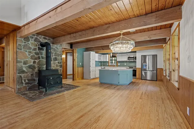 a view of a room with wooden floor furniture and kitchen view