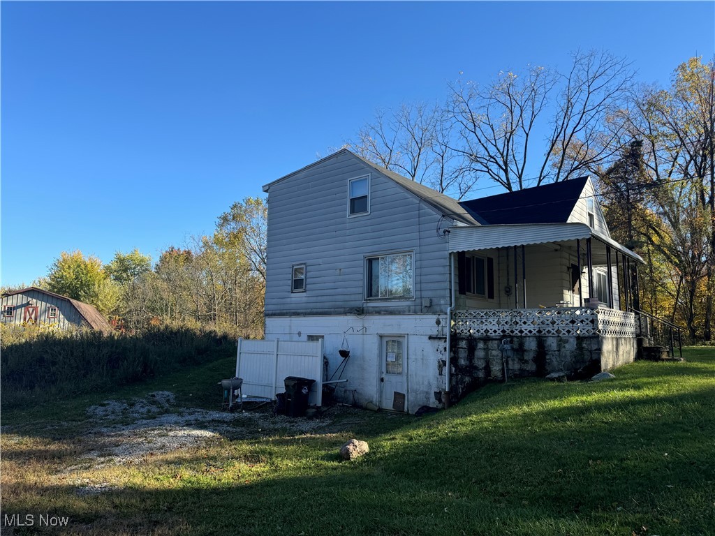 4589 Alger Road Richfield, OH 44286 - Photo 6 of 10 Rear view of house with a yard and a porch