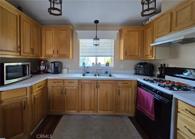 a kitchen with stainless steel appliances a sink stove and cabinets