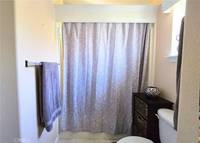 a bathroom with a toilet and a shower curtain