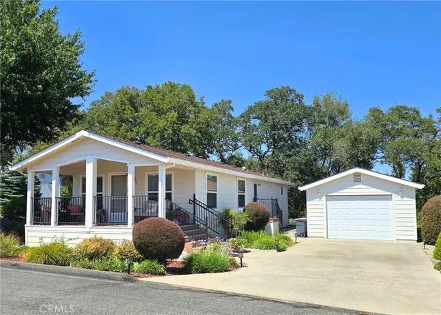a front view of a house with a garden and mountain view